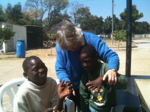 Best friends Blessing and Tino play with Sr. Dominica in their yard at L’Arche Zimbabwe. Photos by Sandy McDonald 